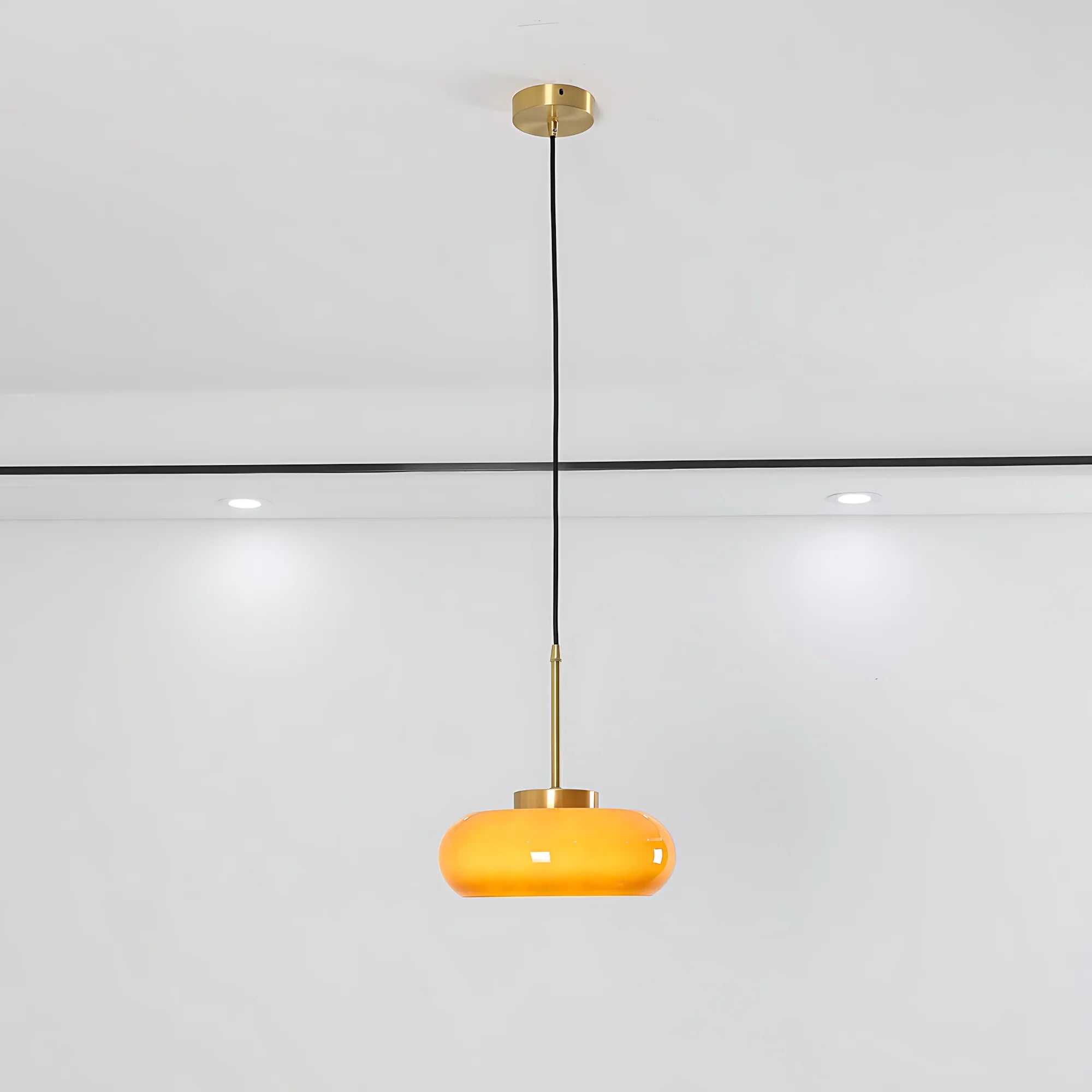 Luna Amber Glass Pendant Light installed above a modern dining table.
