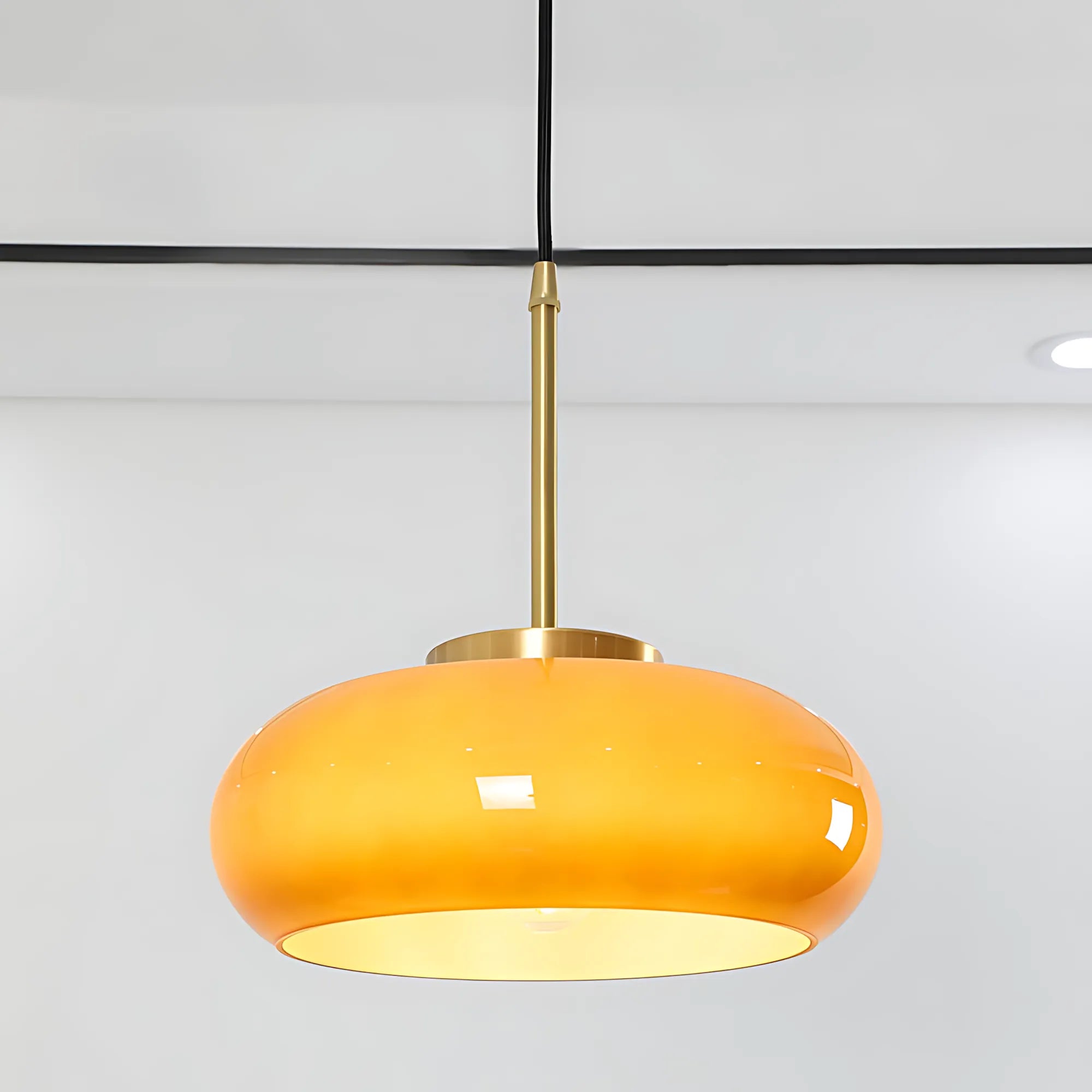 Luna Amber Glass Pendant Light installed above a modern dining table.